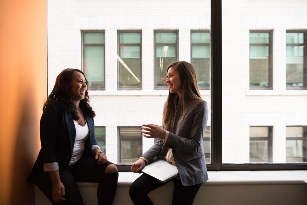 To kvinner har en avslappet samtale på jobb