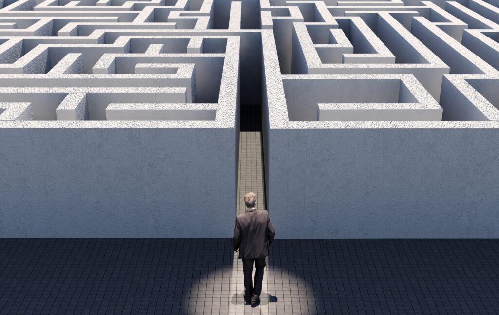Mann står foran en labyrint for å illustrere utfordringer med digital opplæring for å sikre compliance
